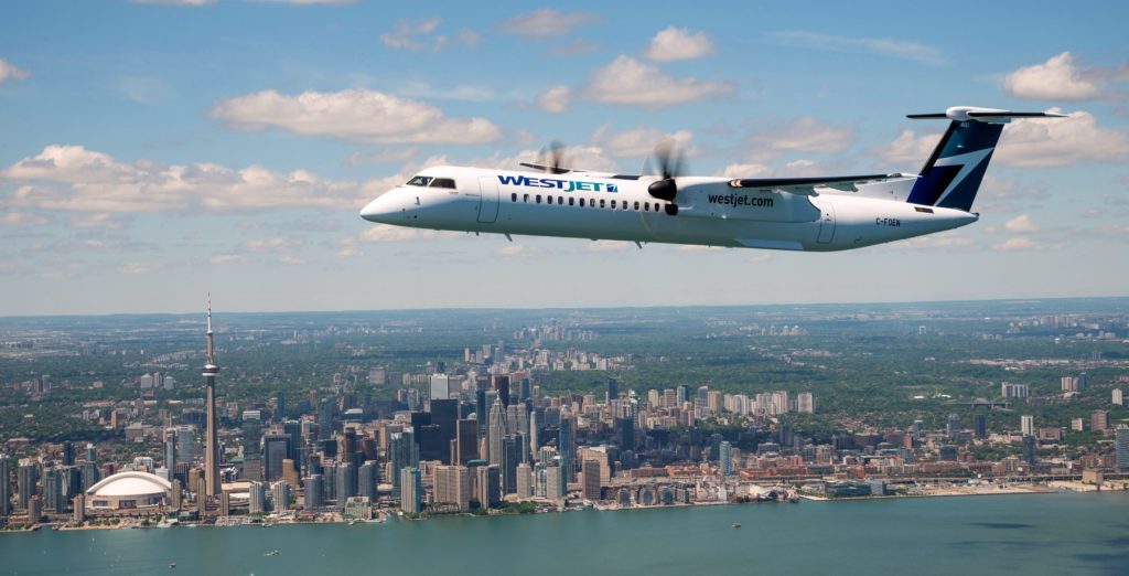 WestJet airplane flying above Toronto